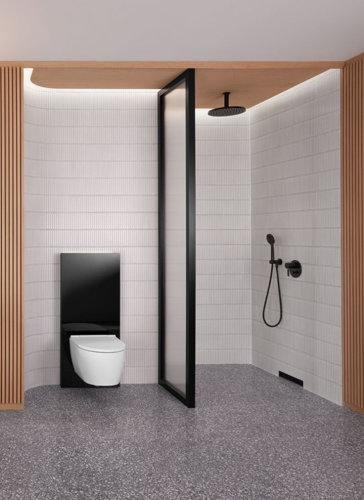 Bagno con parete in legno, con zona doccia e scarico a parete, vaso WC in bianco con Geberit Monolith nero