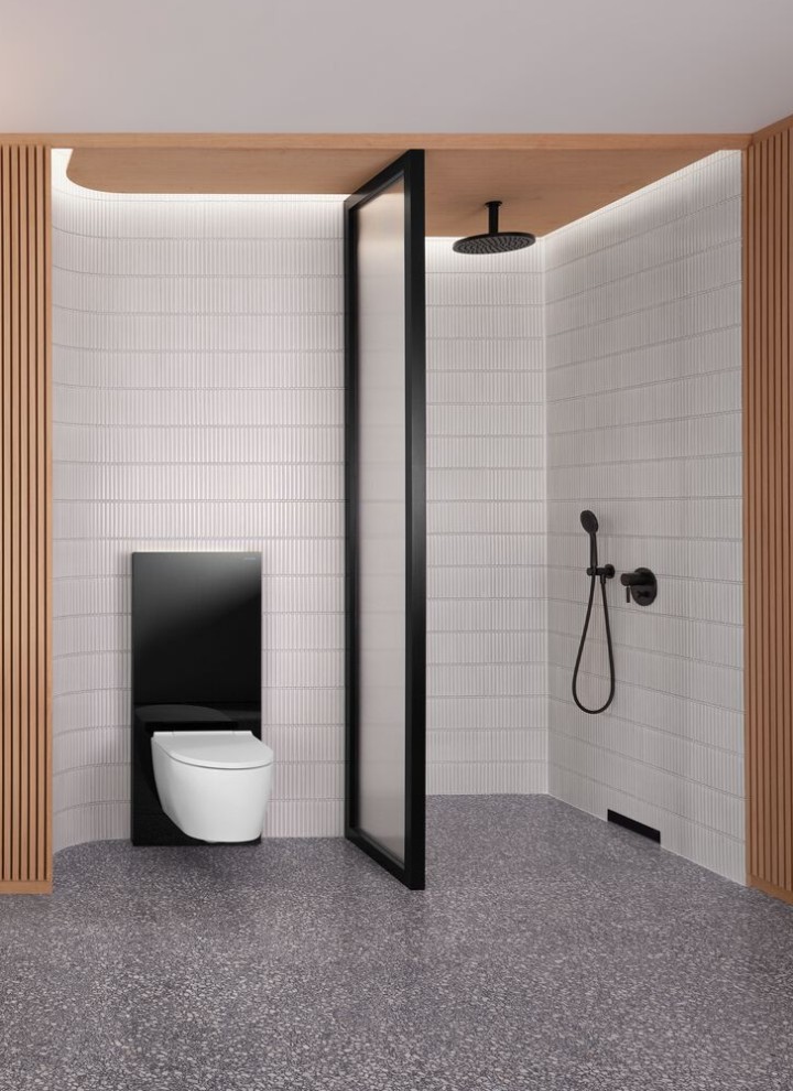 Bagno con parete in legno, con zona doccia e scarico a parete, vaso WC in bianco con Geberit Monolith nero Bagno con parete in legno, con zona doccia e scarico a parete, vaso WC in bianco con Geberit Monolith nero