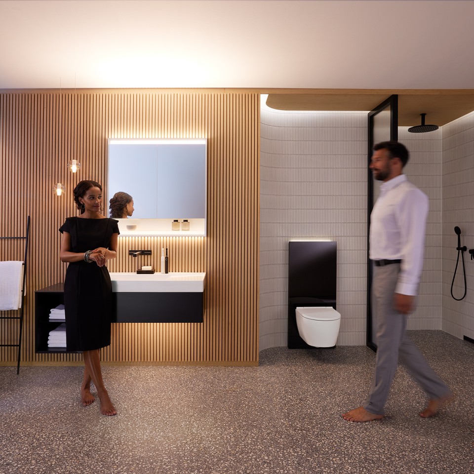 Uomo e donna in un bagno perfettamente illuminato con mobili da bagno e ceramiche Geberit ONE (© Geberit) Uomo e donna in un bagno perfettamente illuminato con mobili da bagno e ceramiche Geberit ONE (© Geberit)