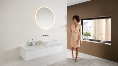Woman in a modern bathroom featuring a brown colour scheme – the latest bathroom colour trend – and a Mix & Match washbasin area combination