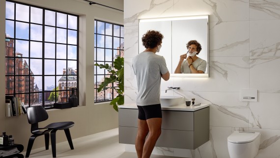 Uomo che si fa la barba al lavabo con mobile e specchio Geberit ONE Uomo che si fa la barba al lavabo con mobile e specchio Geberit ONE