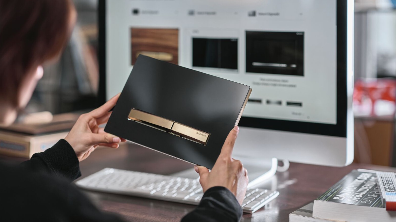 Donna con placca di comando Geberit Sigma50 con pulsante in oro rosa Donna con placca di comando Geberit Sigma50 con pulsante in oro rosa