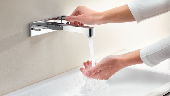 Macro immagine con le mani che girano un rubinetto Geberit ONE e controllano il flusso e la temperatura dell’acqua Macro immagine con le mani che girano un rubinetto Geberit ONE e controllano il flusso e la temperatura dell’acqua