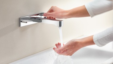 Donna apre il rubinetto e verifica l'intensità e la temperatura del getto d'acqua