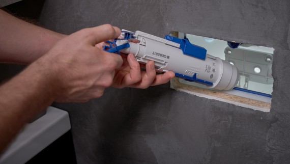 Un installatore monta una valvola di scarico Geberit all’interno di una cassetta di risciacquo da incasso. (© Ben Huggler) Un installatore monta una valvola di scarico Geberit all’interno di una cassetta di risciacquo da incasso. (© Ben Huggler)