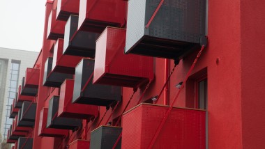 La vivace facciata rossa con i balconi a forma di cubo si fa notare in Goldsteinstrasse a Francoforte sul Meno (DE) (© Geberit)