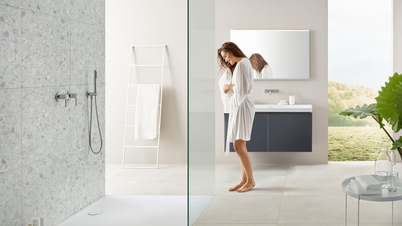 Donna in bagno con doccia walk-in e piatto doccia Geberit Olona. Donna in bagno con doccia walk-in e piatto doccia Geberit Olona.