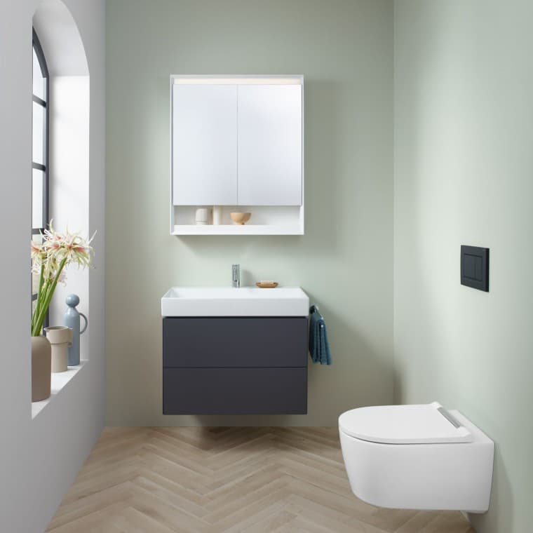Bagno di piccole dimensioni in verde menta con mobile lavabo color lava, mobile specchio, placca di comando e sanitari in ceramica di Geberit Bagno di piccole dimensioni in verde menta con mobile lavabo color lava, mobile specchio, placca di comando e sanitari in ceramica di Geberit